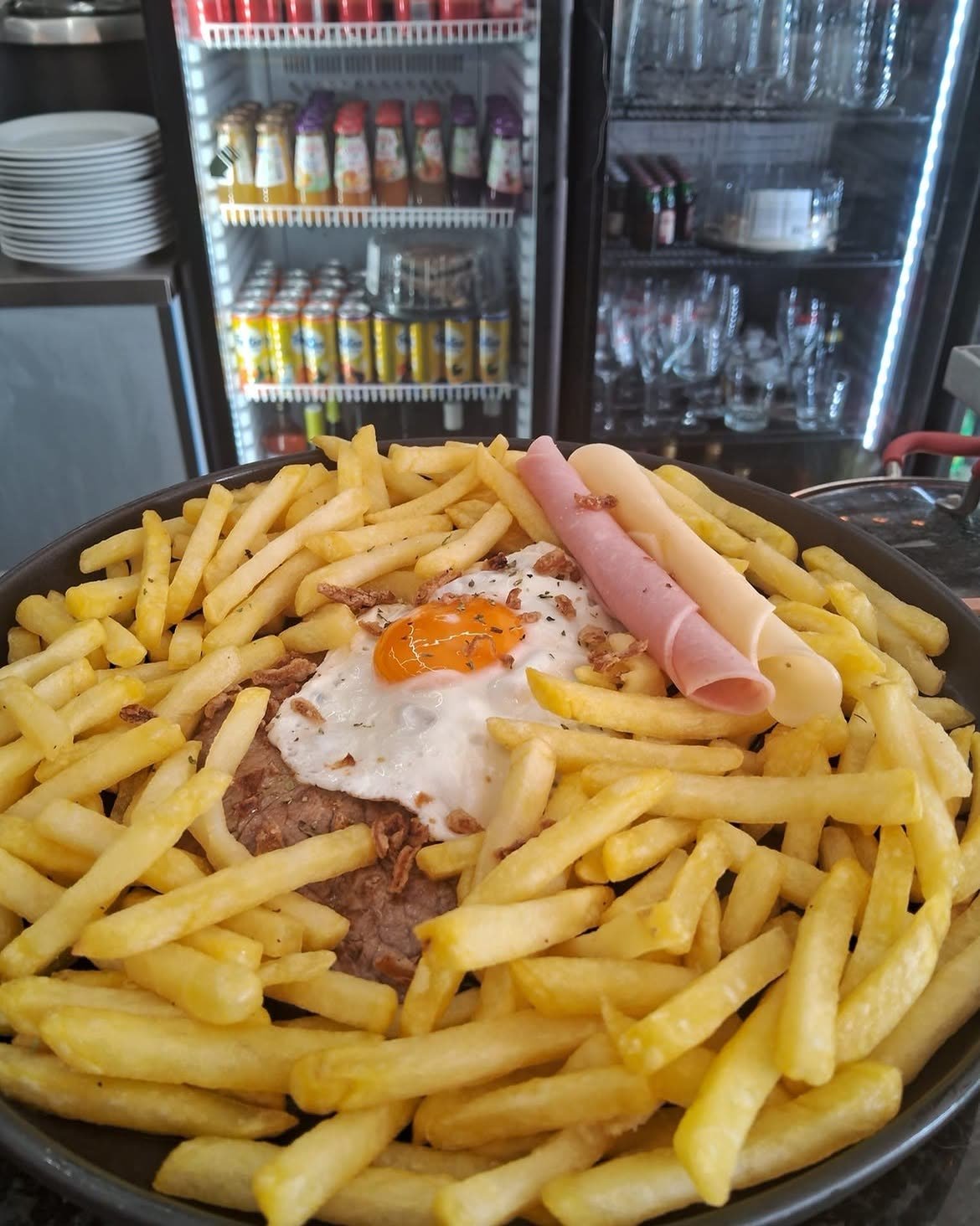 Gegrilltes Capa-Negra-Steak mit Spiegelei, umgeben von Pommes frites