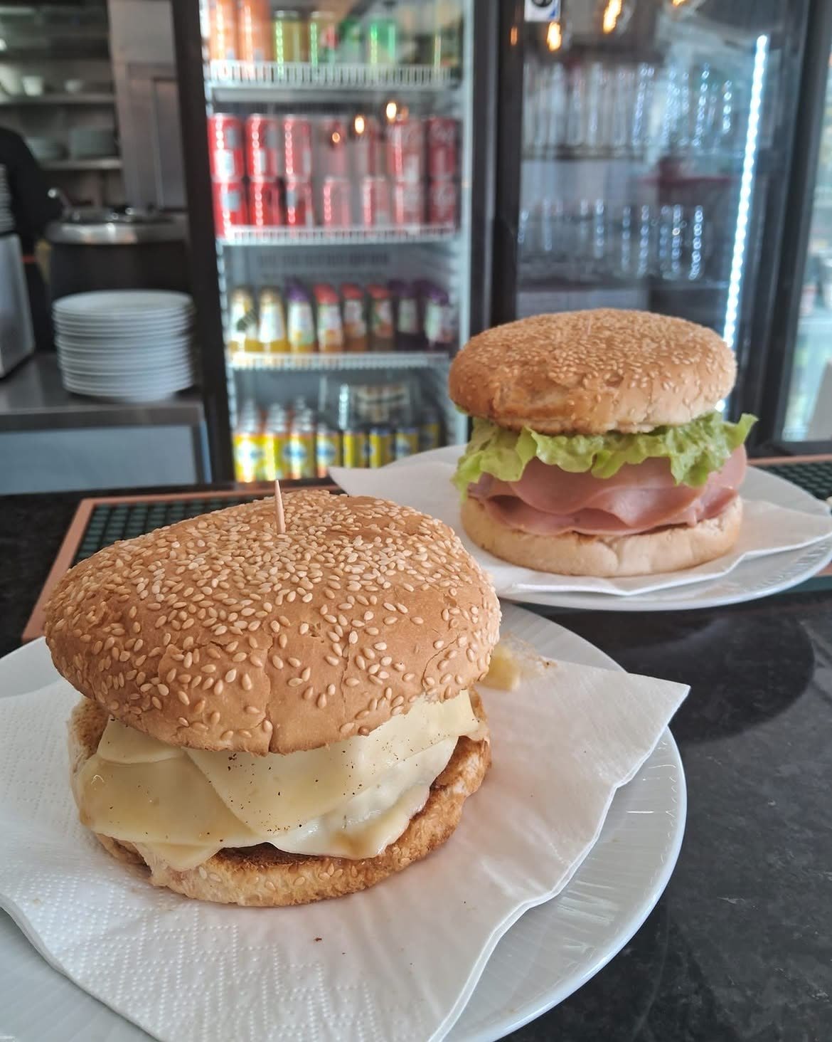Zwei Capa-Negra-Burger auf weißen Tellern an der Theke